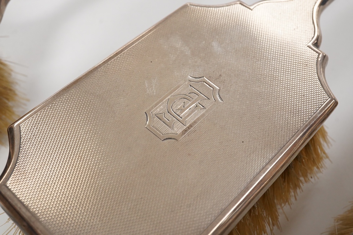 A 1930' matched engine turned silver mounted four piece dressing table brush set, William Comyns & Sons Ltd, London, 1933,36,38 & 39.